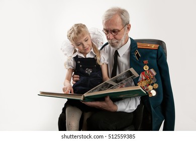 Old Man In Army Uniform With Rewards And Beautiful Little Girl On Isolated Studio Background