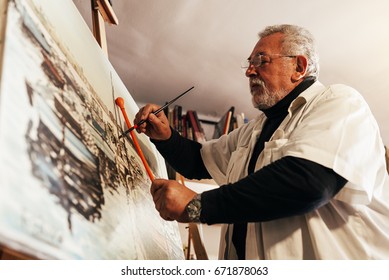 Old Man Artist Painting Oils In His Studio.