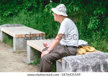Old man in bench enjoying the afternoon in a park in Kyoto