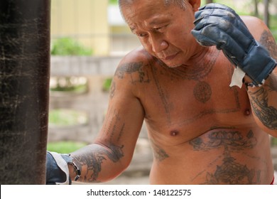 The Old Man Boxer Punching The Sand In Boxing, His Body Full Of Tattoo