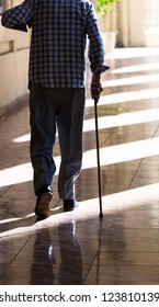 An Old Man With A Cane On The Sidewalk