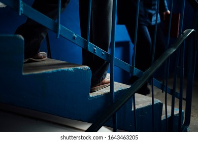 the old man carefully descends the stairs, walking heavily on the steps with the support of a caring young man - Powered by Shutterstock