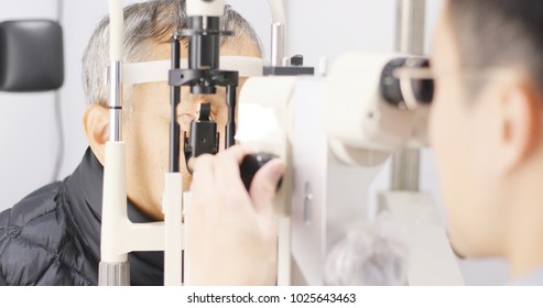 Old Man Checking On Eye In Clinic 