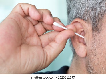 Old Man Cleaning Ear Using Cotton Stick