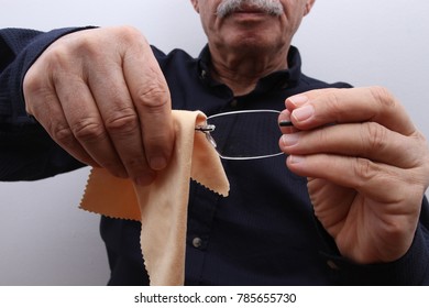 An Old Man Cleaning His Eyeglasses