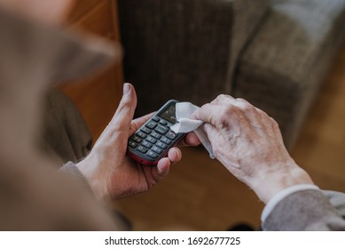 Old Man Cleaning Phone To Prevent Covid-19 Infection