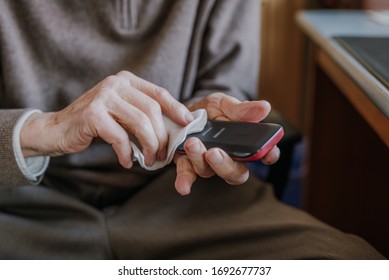 Old Man Cleaning Phone To Prevent Covid-19 Infection