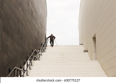 Old Man Climbing Up The Stairs With His Walking Stick 