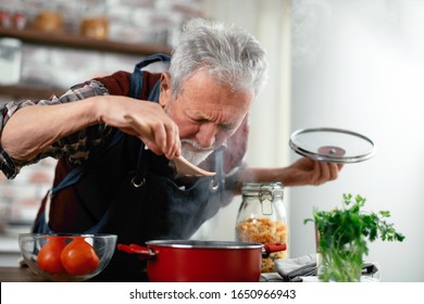 Old man cooking. Senior man in kitchen.  - Powered by Shutterstock