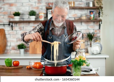 Old Man Cooking. Senior Man In Kitchen. 