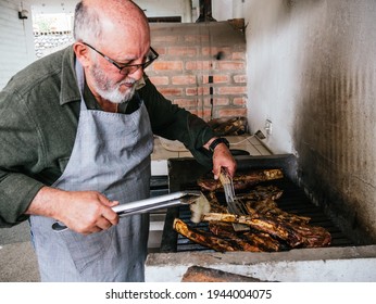 Old Man Cooking Tomahawk Rib Beef Steak On Hot Black Grill With Flames, Rib Eye