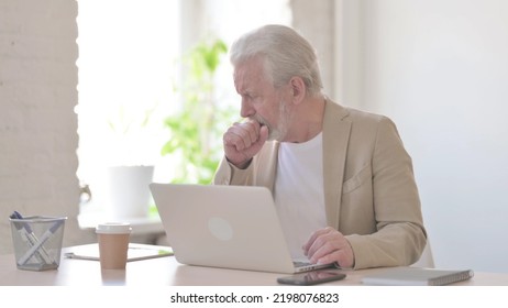 Old Man Coughing While Using Laptop In Office