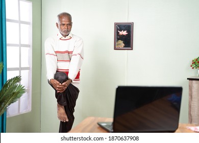 Old Man Doing Exercise At Home By Looking Into Laptop - Concept Of Online Gym Class Due To Coronavirus Covid-19 Pandemic