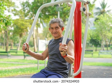 An Old Man Doing Exercise At Outdoor Fitness Equipment In The Park, Concept Health Care In Elderly People, Lifestyle                                 