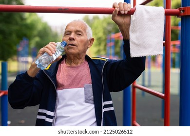 Old Man Drinking Water Beside Pullup Bar