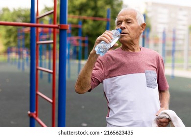 Old Man Drinking Water In Outdoor Workout