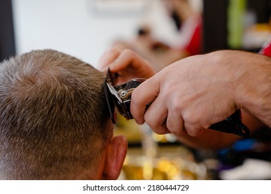 An Old Man Enjoing Haircut By A Master In A Barbershop. An Old Man Gets A Stylish Haircut