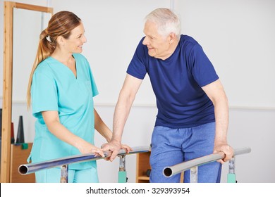 Old Man Exercising With Physiotherapist On A Horizontal Bar