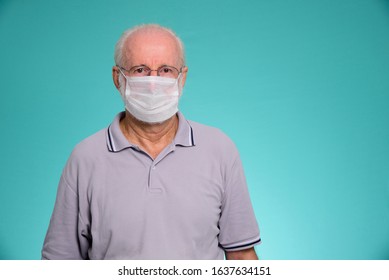 Old Man With Face Mask Against Virus, Grandfather On Green Background. Brazilian Man.