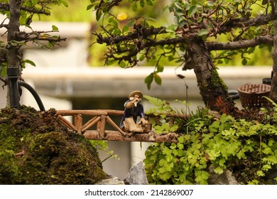 Old Man Figure Sitting On A Bridge