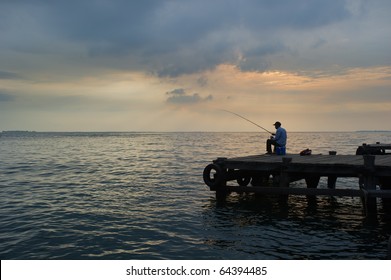 Old Man Fishing At The Dock