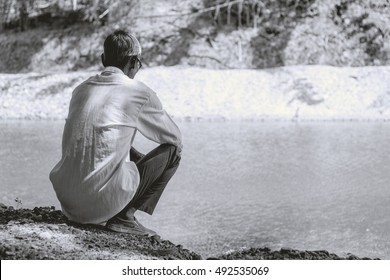 old man in glasses sitting near pond, black&white colour