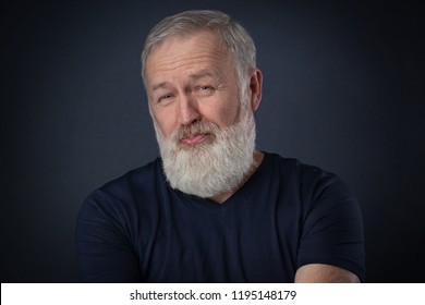 Old Man With Gray Beard Posing A Despise Grimace In Studio