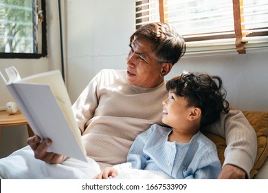Old man with gray hair tell the bedtime story for his grandson for daytime sleep. - Shutterstock ID 1667533909