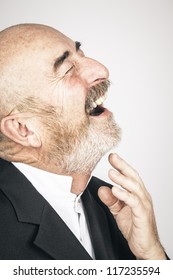 An Old Man With A Grey Beard Is Laughing