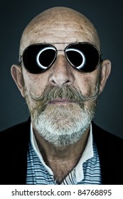 An Old Man With A Grey Beard Wearing Sunglasses