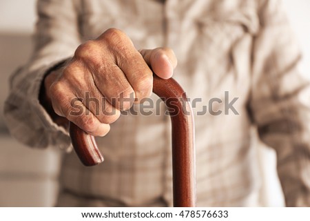Old man hand holding walking stick