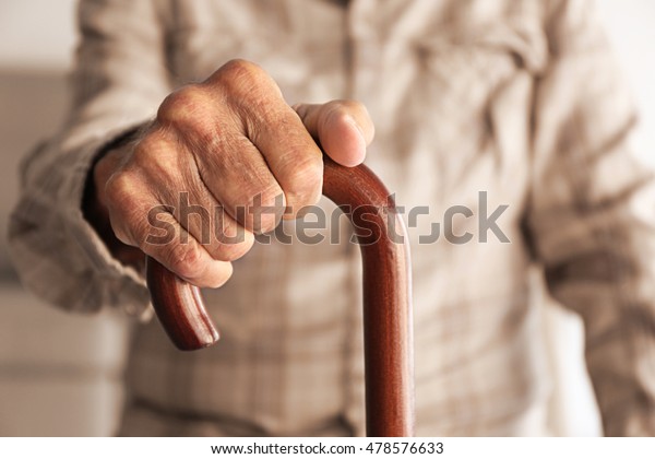Old man hand holding\
walking stick