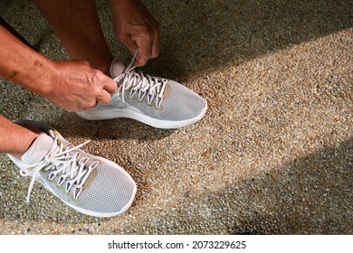 Old Man Hands Tying Shoe For Go Out Jogging In Early Morning Sunlight