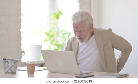 Old Man Having Back Pain While Using Laptop In Office