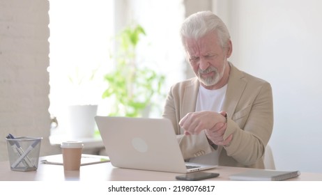 Old Man Having Wrist Pain While Using Laptop In Office