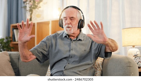 Old man, headphones and dancing in home, music and having fun in retirement or streaming sound. Elderly male person, playlist and living room hip hop for audio therapy, freedom and listening on sofa - Powered by Shutterstock