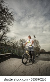 Old Man With His Bike On Skate Park