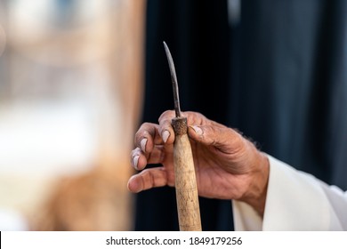 Old Man Holding A Knife Or Tool To Open Shells From The Pearl Diving 