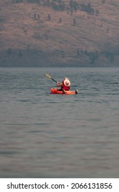 Old Man Kayaking In A Lake In Kelowna British Columbia On A Smoky Day Through 2021 Fires.