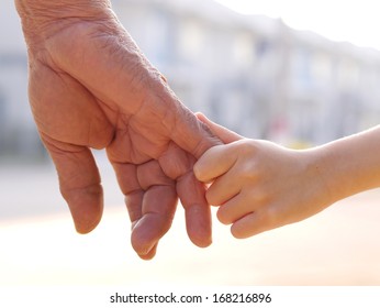 old man and a kid holding hands together