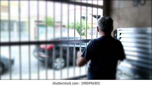 Old Man Leaving Home Through Garage Gate. Senior Stepping Outside