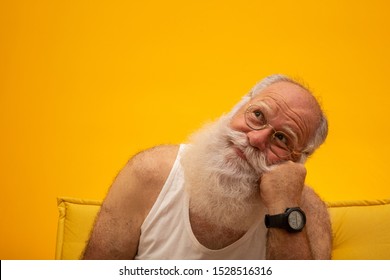 Old Man With A Long Beard On A Yellow Background. Senior With Full White Beard. Old Man With A Long Beard With Sadness.