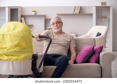Old man looking after newborn at home - Powered by Shutterstock