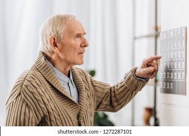 Old Man Looking At Calendar And Remembering Dates