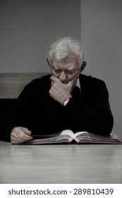 Old Man Looking At Family Photo Album