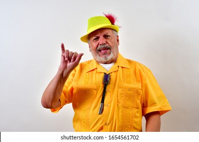 Old Man Makes The Hook Em Horns Sign With His Thumb And Small Finger.
  Elderly Gentleman Raises His Thumb And Little Finger For The Hook Em Horns Sign.