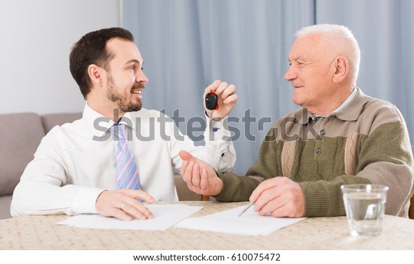 Old man and manager signed contract car lease at\
home and hand over keys
