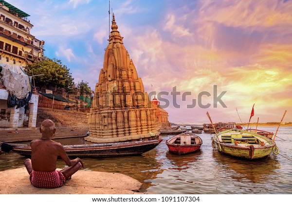 老人は日の出のとき 木のボートや古い建築を見てバラナシ ガンジス川の岸に瞑想をしています の写真素材 今すぐ編集