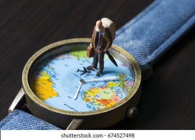 Old man on watches with world map. World travel photo banner. Senior traveler figurine. Retired backpacker travel. World time zones. Travelling around world concept. Senior age travel. Time of life