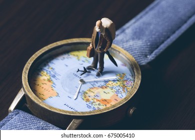 Old Man On Watches With World Map, Vintage Toned Photo. World Travel Banner. Senior Traveler Figurine. World Time Zones. Travelling Around World Concept. Senior Age Travel. Time Of Life In Vacation